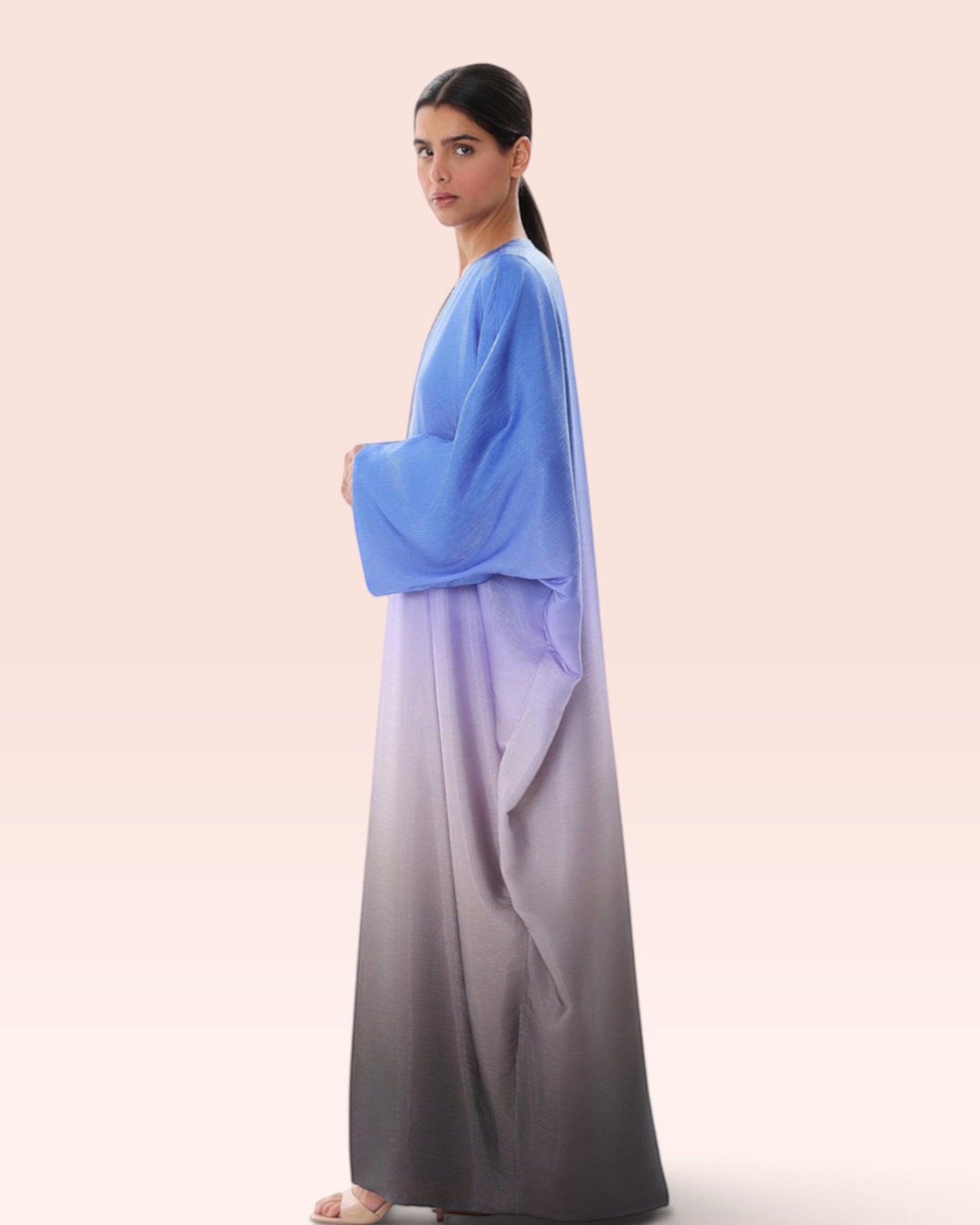 Model wearing an Amore Abaya Boutique blue to grey ombre bisht abaya with flowy sleeves for a special occasion