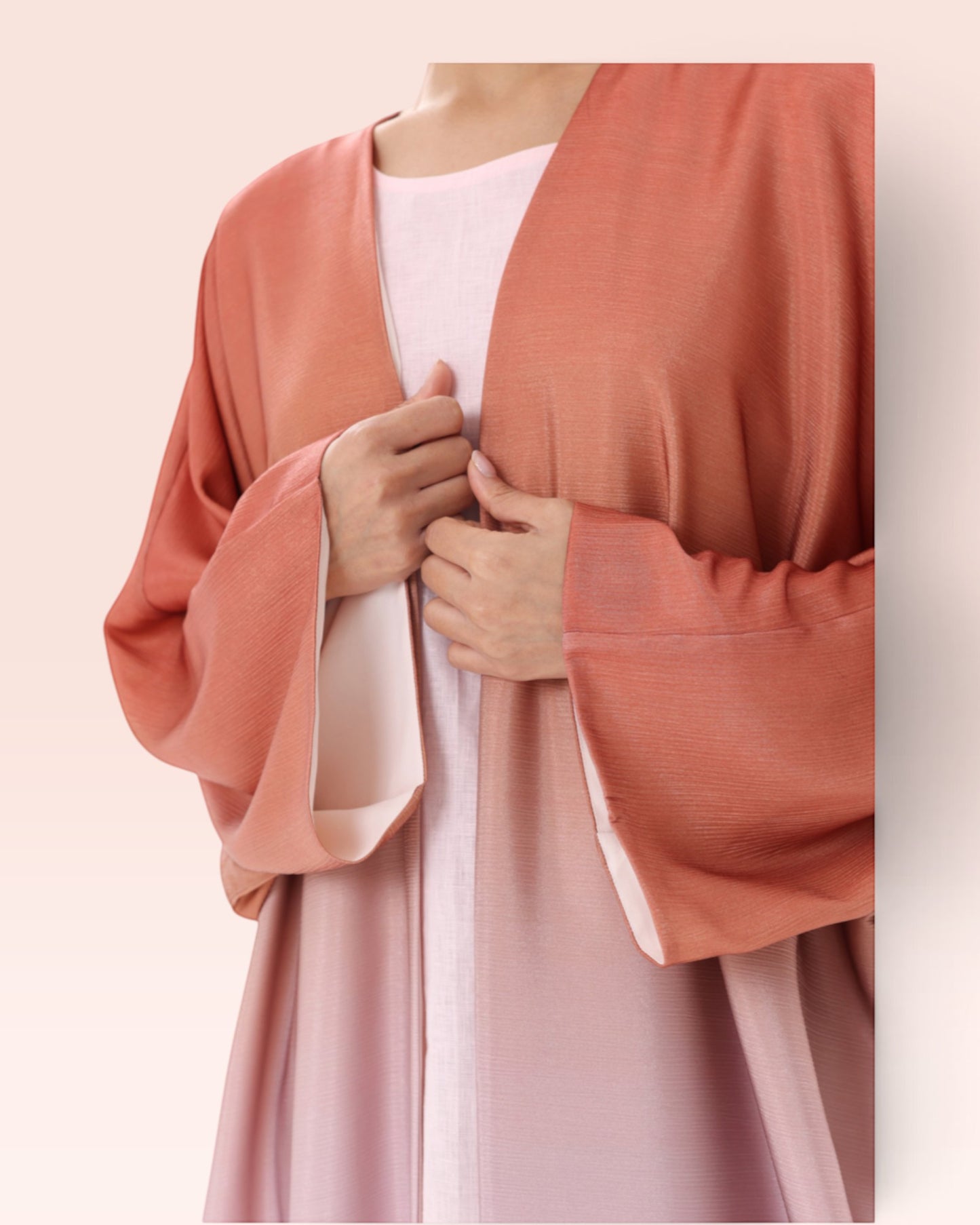 Amore Abaya Boutique Sunset Ombre Bisht Abaya in lightweight, flowy fabric with a soft coral and pink gradient.